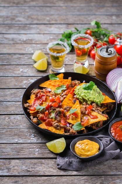 Premium Photo | Yellow corn tortilla chips nachos with ground beef ...