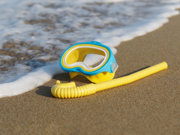 Download Premium Photo Yellow Diving Mask And Snorkel For Children On The Beach Sand With Soft Ocean Wave PSD Mockup Templates