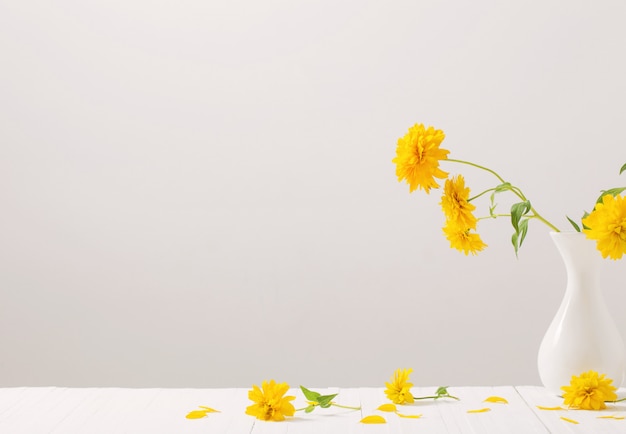 Premium Photo | Yellow flowers in vase on white wall