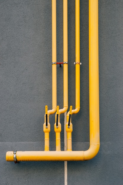 Premium Photo | Yellow gas pipe with a crane goes along the facade of a ...