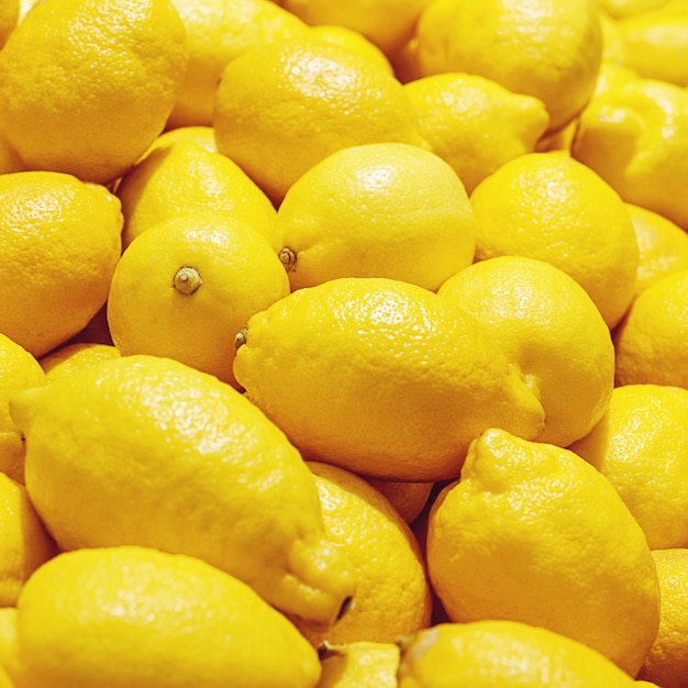イエローレモンは果物市場 明るいレモン背景でクローズアップ プレミアム写真