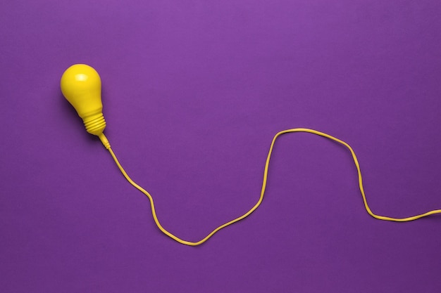 premium-photo-a-yellow-light-bulb-on-a-long-yellow-wire-on-a-purple