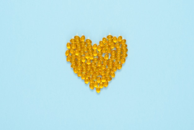 Download Yellow pills arranged in a shape of heart | Premium Photo