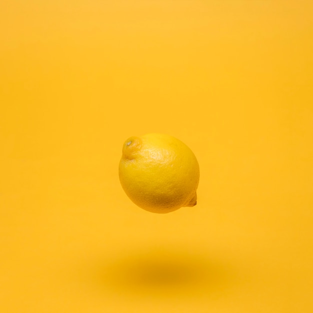 Yellow still life of floating lemon Photo | Free Download