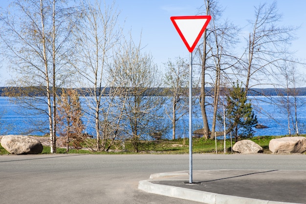 Premium Photo Yield Sign On Road Next The Blue Lake