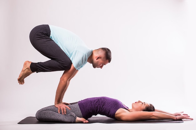 Concetto Di Yoga Giovani Coppie In Buona Salute Nella Posizione Di Yoga Su Priorita Bassa Bianca Foto Gratis