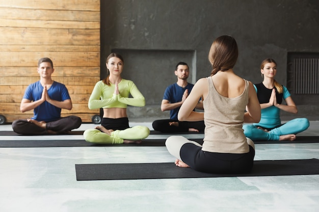 Premium Photo | Yoga teacher and beginners in class, making asana ...