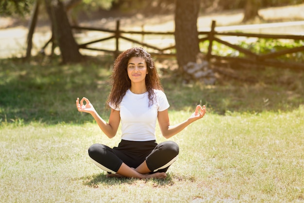 Premium Photo | Young arab woman doing yoga in nature