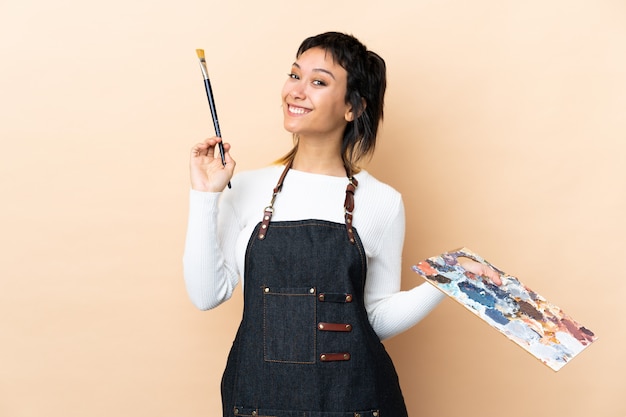 Premium Photo | Young artist man holding a palette over isolated background