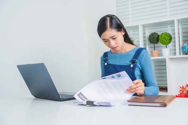 Premium Photo | Young asian business female with paperwork financial working serious at home.