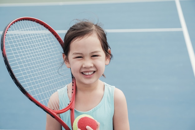 Premium Photo | Young asian girl tennis player on outdoor blue court