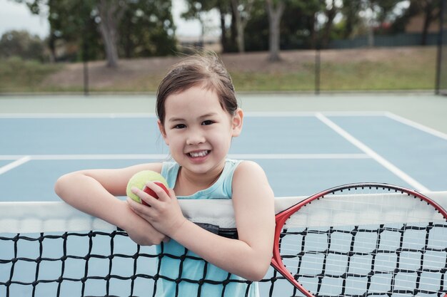 Premium Photo | Young asian girl tennis player on outdoor blue court