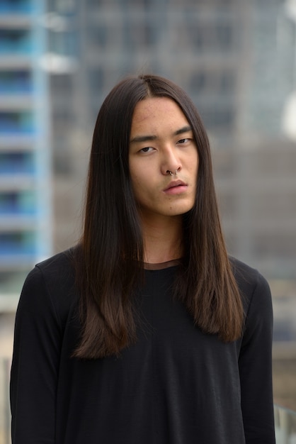 Premium Photo Young Asian Man With Long Hair In The City Outdoors