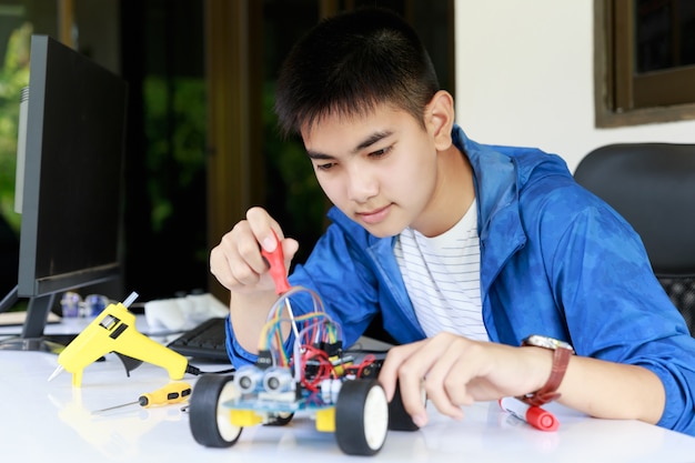 Young asian teen enjoy with toy car workshop. Premium Photo