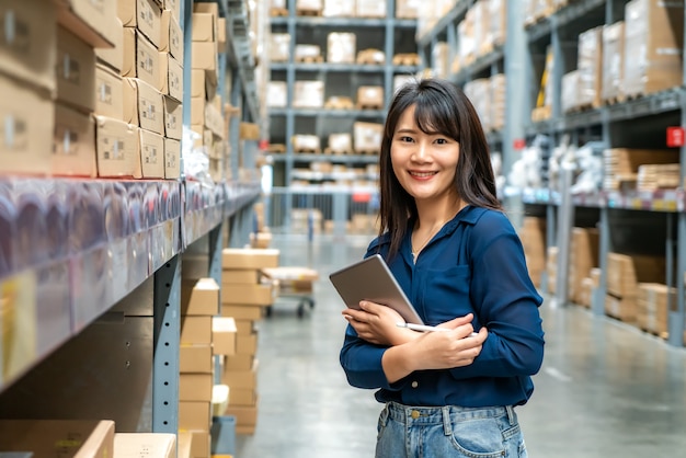 Young asian woman auditor or trainee staff work looking up and checks the number of items store by digital tablet. Premium Photo