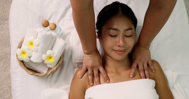 Premium Photo | Young asian woman receiving a shoulder massage at spa ...