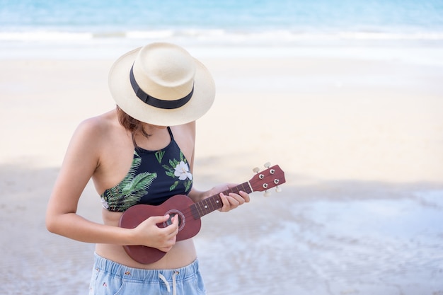 Premium Photo Young Asian Woman Wear Swimsuit Playing On The Ukulele At Beach