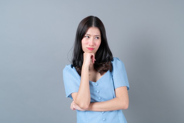 Premium Photo | Young asian woman with sulk face in blue dress on grey