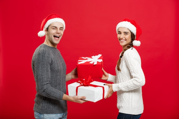 Premium Photo | Young attractive couple giving gifts to each other ...