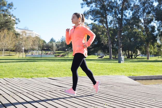 Young attractive woman jogging in city park | Free Photo