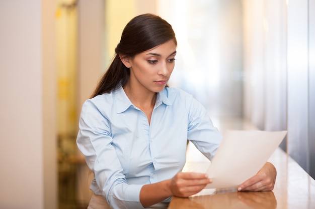 Young Attractive Woman Reading Document in Cafe Photo | Free Download