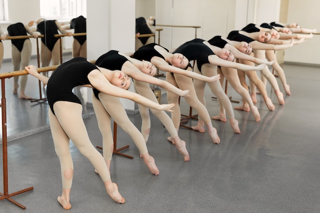 Premium Photo Young Ballerinas Doing Exercises In Studio Young Ballet Actresses Training Dance Move At Ballet Barre In Dance Class Flexibility And Skills Of Young Ballerinas Bodies