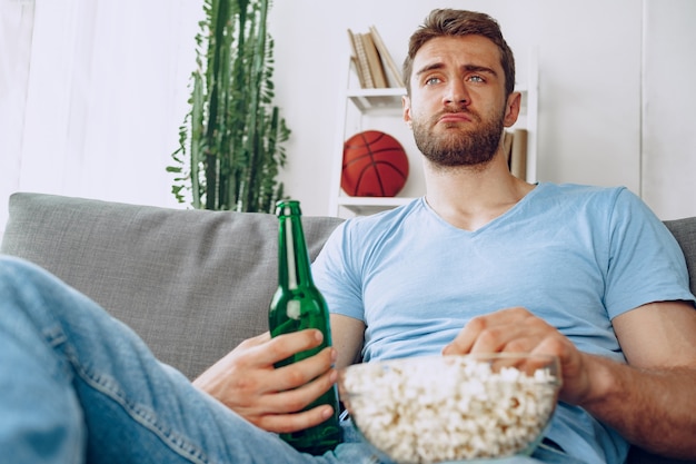 Premium Photo Young Bearded Man Sitting On Couch With Beer And