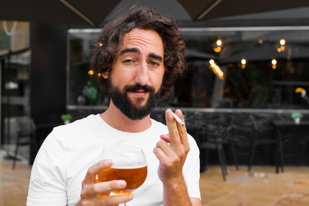 Young bearded man smoking and drinking a beer Premium Photo