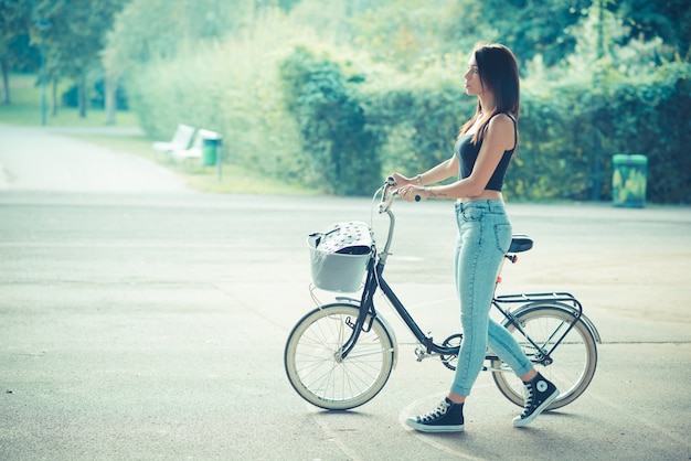 Premium Photo | Young beautiful brunette straight hair woman using bike