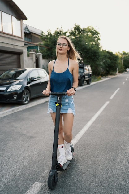 Free Photo Young Beautiful Girl Riding An Electric Scooter In The Summer On The Street 1254