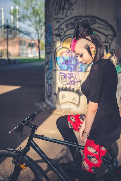 Young beautiful punk dark girl riding bike Premium Photo