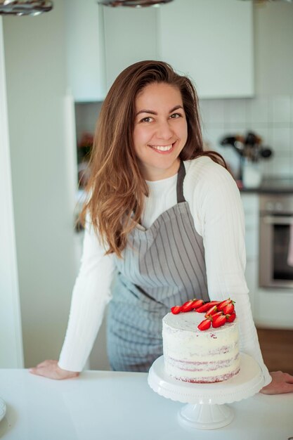 Premium Photo | Young beautiful woman bakes a cake. sweets. confectionery.