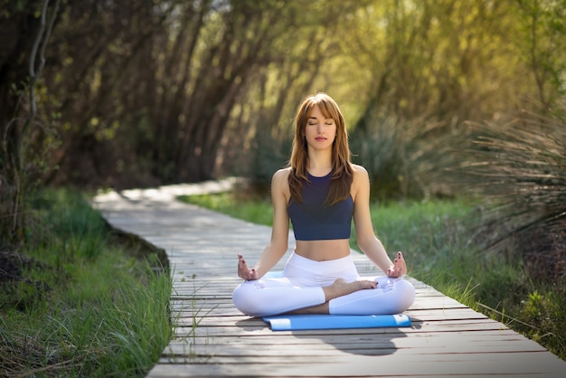 Young beautiful woman doing yoga in nature Free Photo