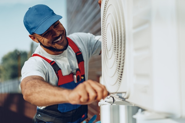 Premium Photo | Young black man repairman checking an outside air ...