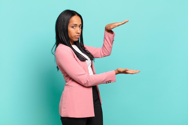 Premium Photo | Young black woman holding an object with both hands on ...