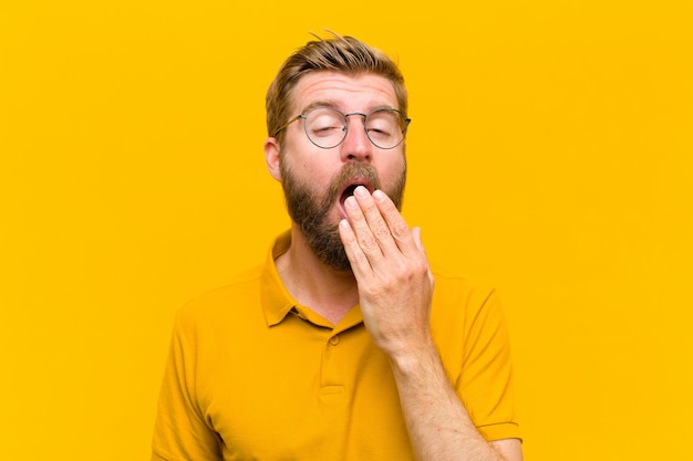 Premium Photo | Young blonde man yawning lazily early in the morning