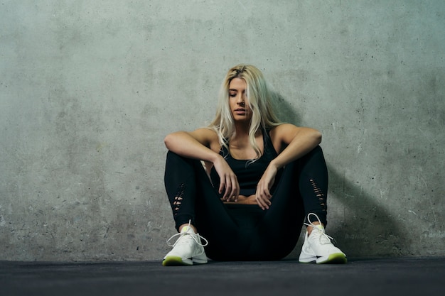 Premium Photo Young Blonde Woman Sitting In The Gyms Floor