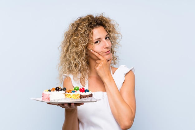Download Free Young Blonde Woman With Curly Hair Holding Lots Of Different Mini Use our free logo maker to create a logo and build your brand. Put your logo on business cards, promotional products, or your website for brand visibility.