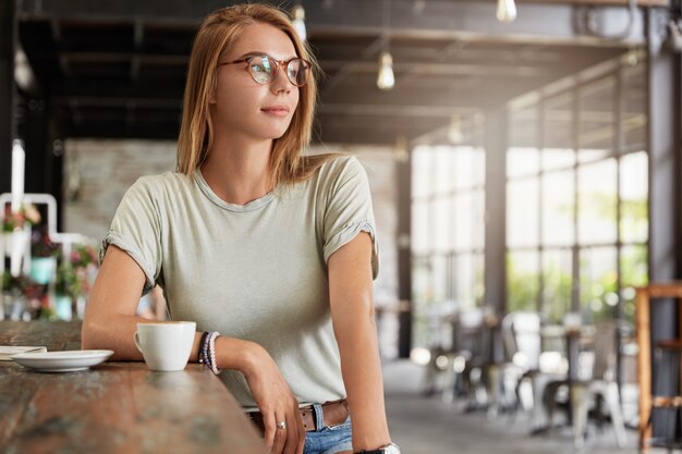 Free Photo | Young blonde woman with glasses in cafe