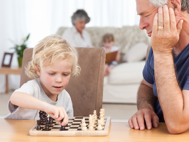 Premium Photo Young Boy Playing Chess With His Grandfather