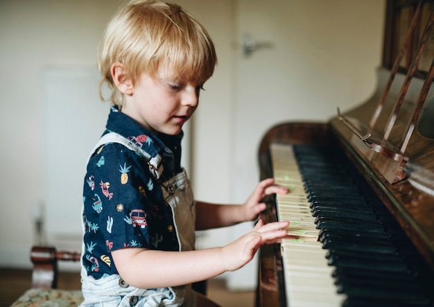 Premium Photo | Young boy playing a piano