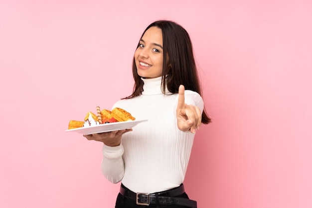 Premium Photo | Young brunette woman holding waffles isolated