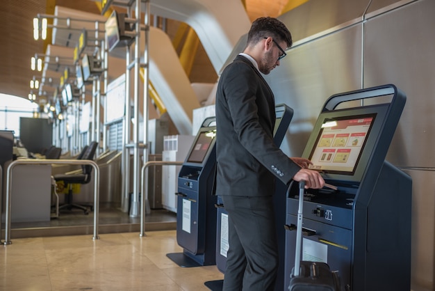 Premium Photo | Young business man doing self check in a machine at the ...