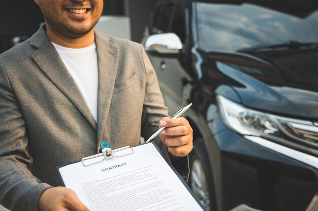 Premium Photo | A young business man signs a luxury car leasing ...