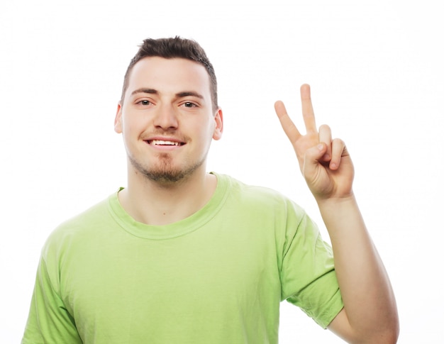 Premium Photo | Young casual man showing the victory gesture