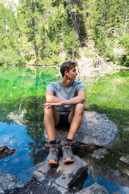 Premium Photo | Young caucasian man relaxing of a lake during a ...