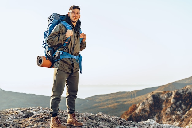 山でのハイキングの大きなバックパックを持つ若い白人男性旅行者 プレミアム写真