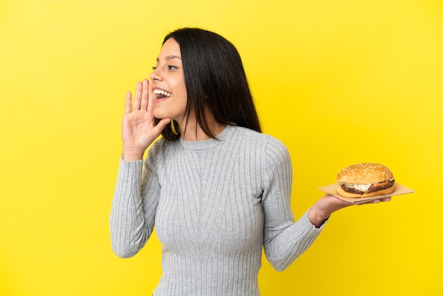 Premium Photo | Young caucasian woman holding a burger isolated on ...