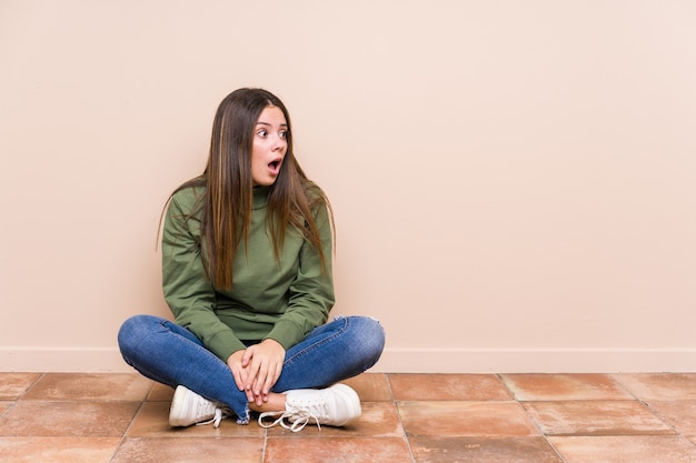 Premium Photo | Young caucasian woman sitting on the floor isolated