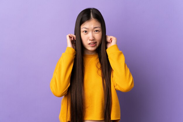 Premium Photo | Young chinese girl isolated frustrated and covering ears